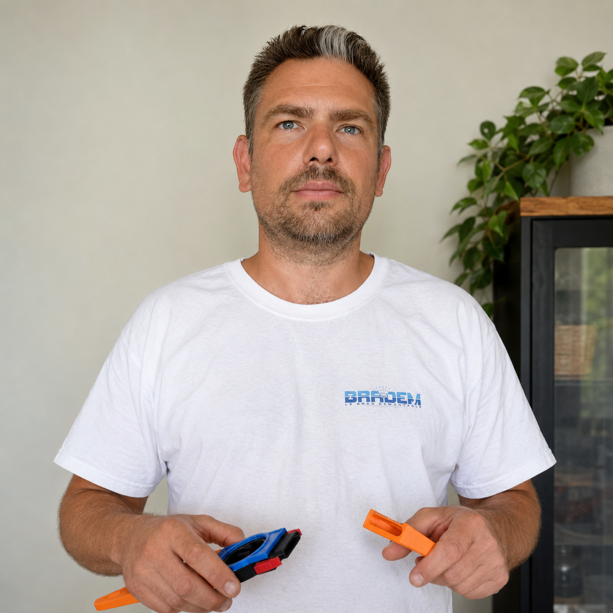 Sébastien Blaise, inventeur de Bradem, tenant les pièces du bras démontable
